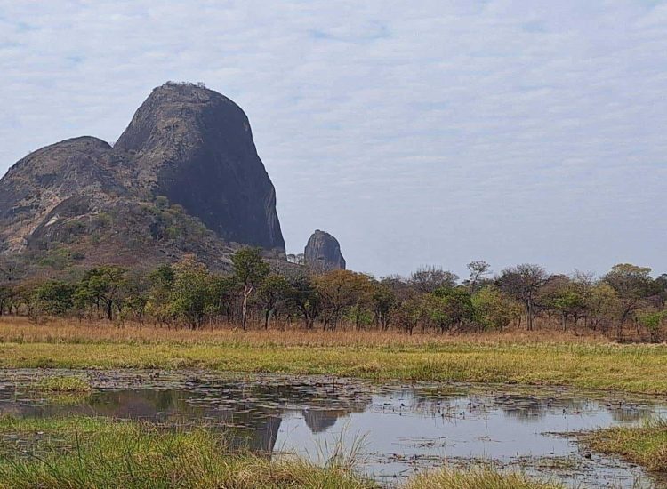 Mozambique Hunting Scenic view of African landscape with mountains and water body.