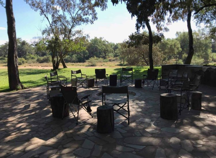 Zimbabwe Hunting Outdoor seating area with chairs and tables under trees at Graham Sales Safaris.