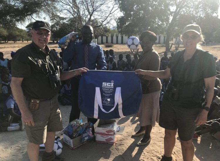 Zimbabwe Hunting Safari guides and local community members exchanging gifts outdoors.
